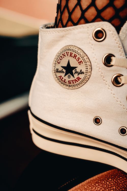 Free Detailed view of a classic white canvas sneaker showcasing fashion and style elements. Stock Photo