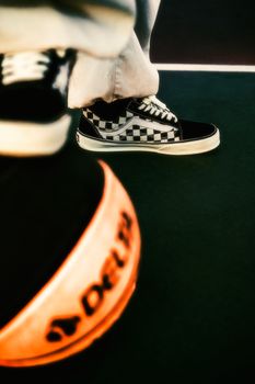 Close-up of stylish sneakers and basketball on an urban court. Perfect for street style and sports themes.