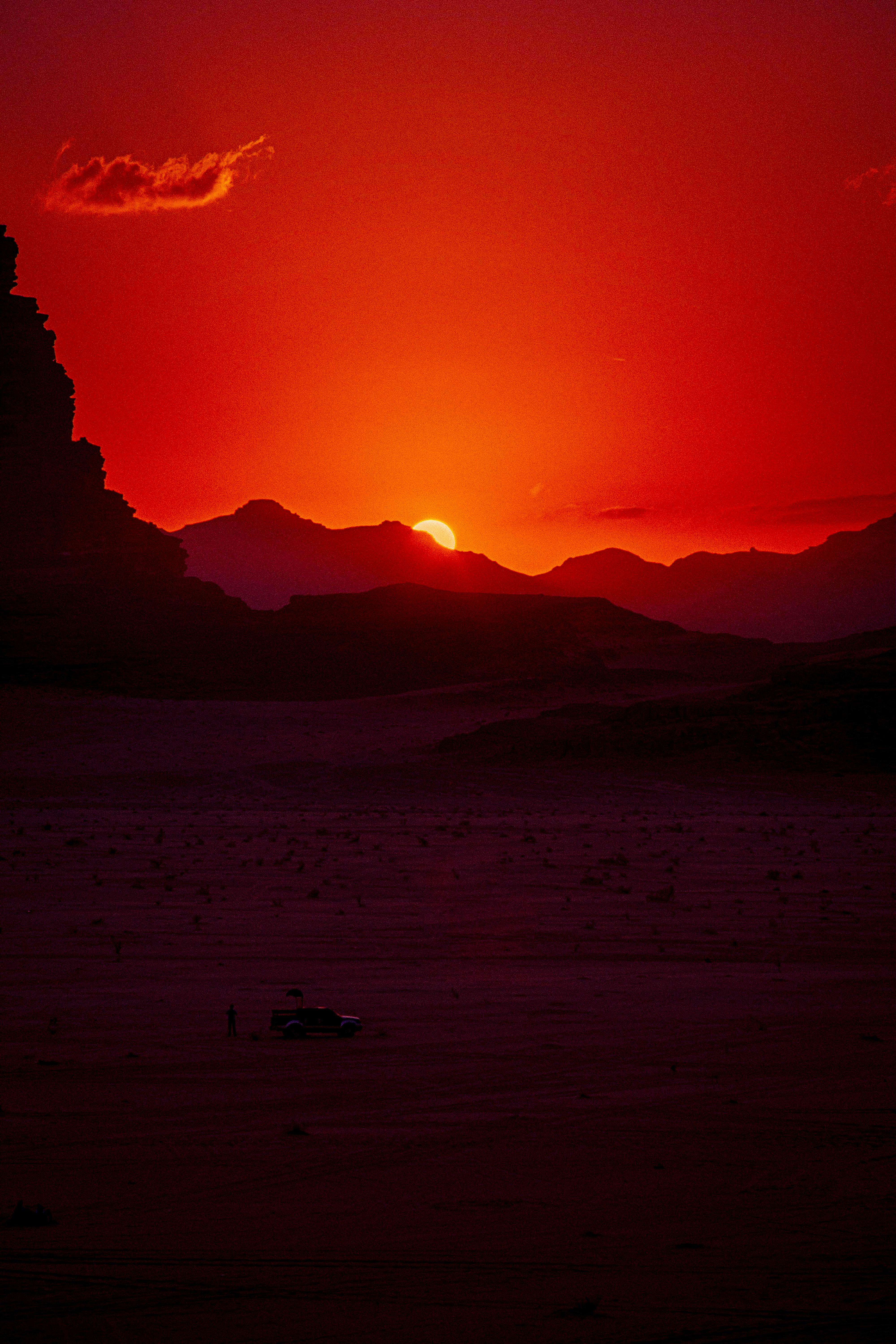 Breathtaking sunset over the desert landscape of Wadi Rum, Jordan, with vibrant red hues.