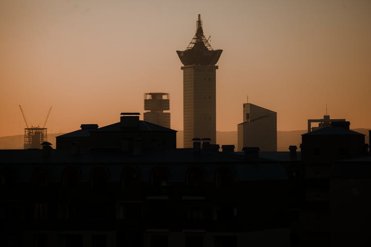 Buildings Under Yellow Sky In Town At Sunset