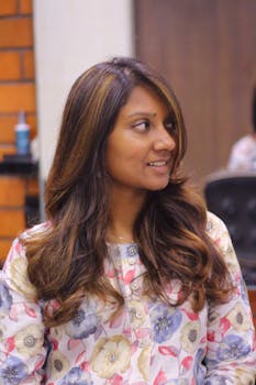 Portrait of a smiling woman with long brown hair wearing a colorful floral shirt.