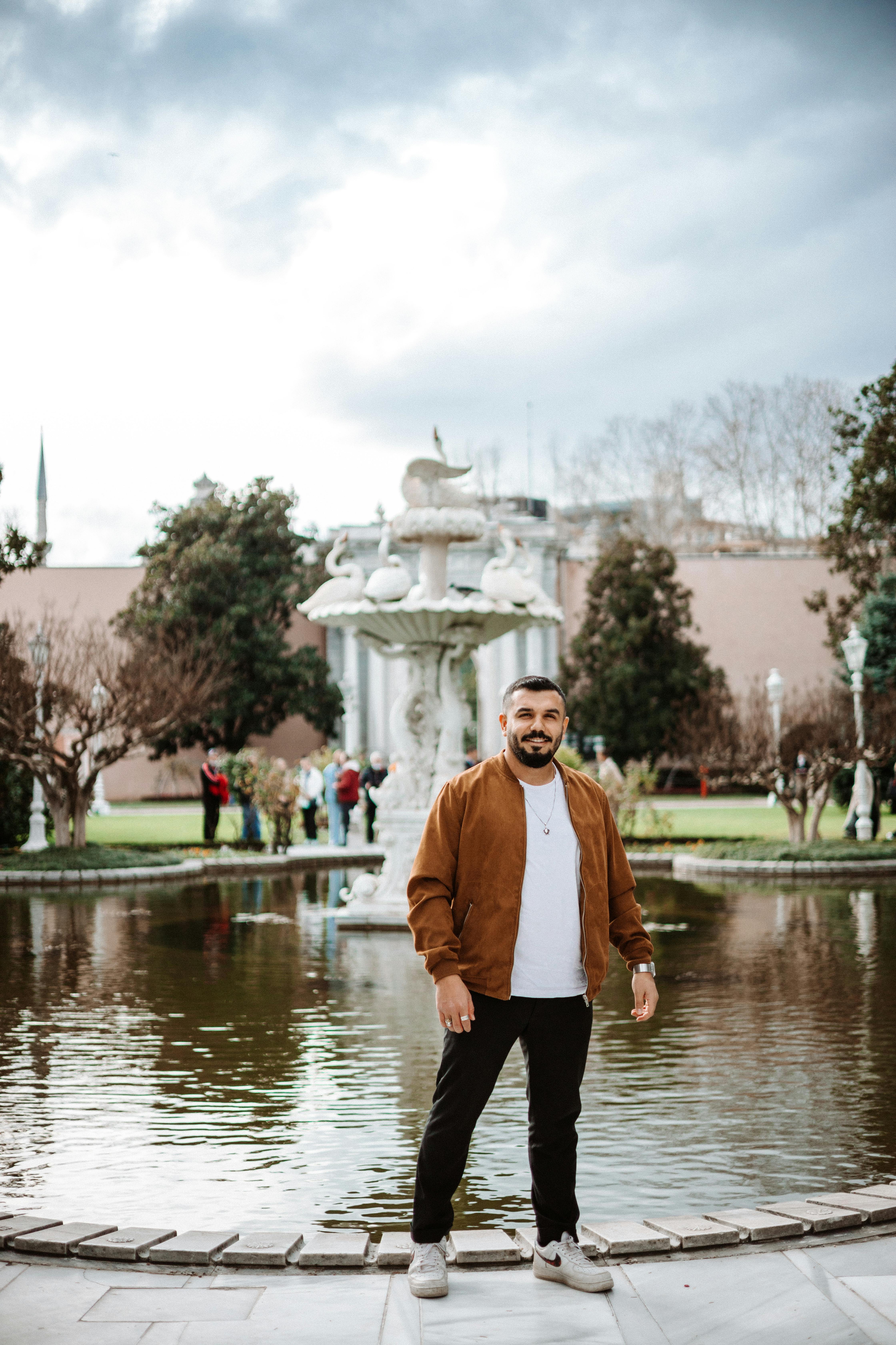 a man standing in front of a fountain