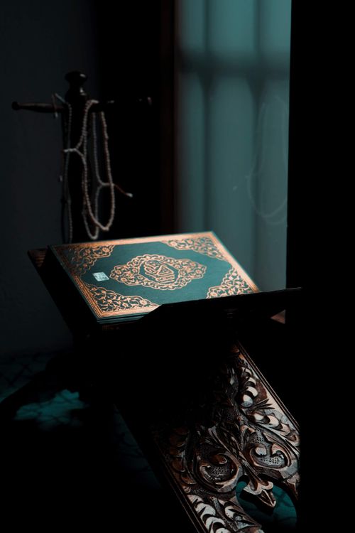Free Ornately designed Quran resting on a stand in a dimly lit Istanbul room. Stock Photo
