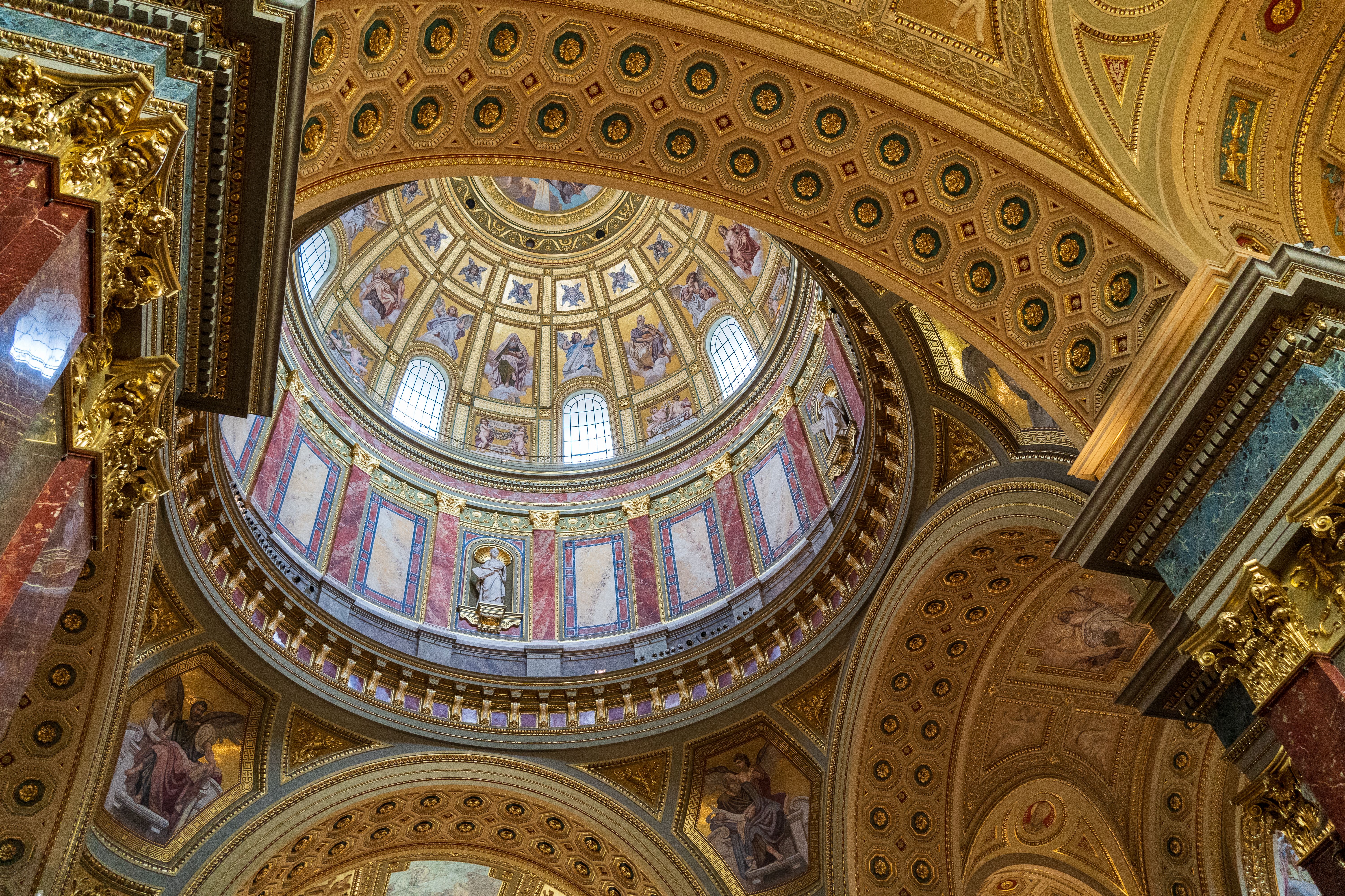 Stunning interior of a neoclassical cathedral dome with detailed religious artwork.