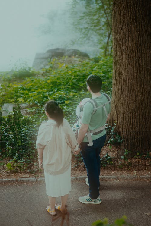 Couple Holding Hands and Standing on Road