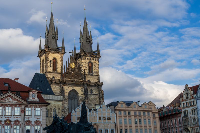 Gothic architecture of Tyn Church in Prague's Old Town under a vibrant sky.