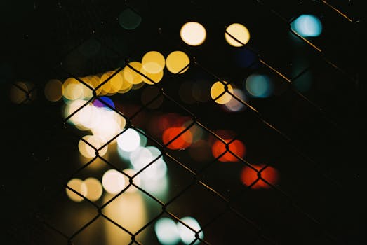 Bokeh effect of city lights in Istanbul at night through a fence.