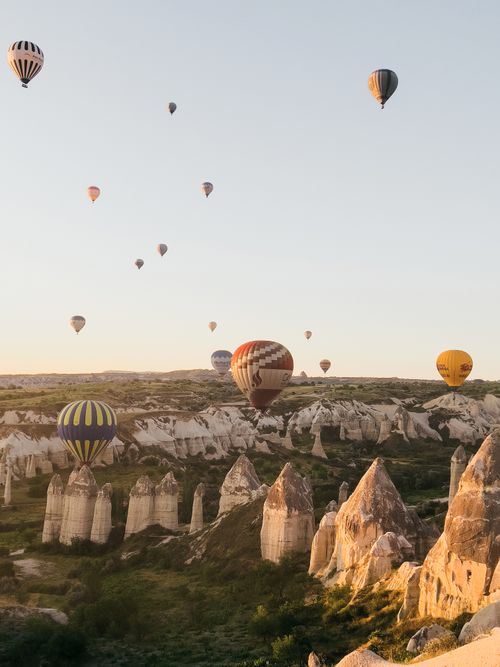 Free Breathtaking view of hot air balloons floating over Cappadocia's unique rock formations at sunrise. Stock Photo