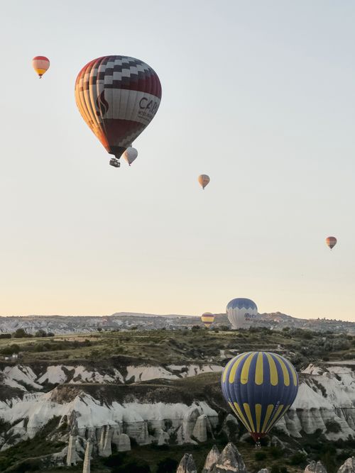 Free Hot air balloons soar over the captivating landscapes of Cappadocia in Türkiye, perfect for adventure and sightseeing. Stock Photo