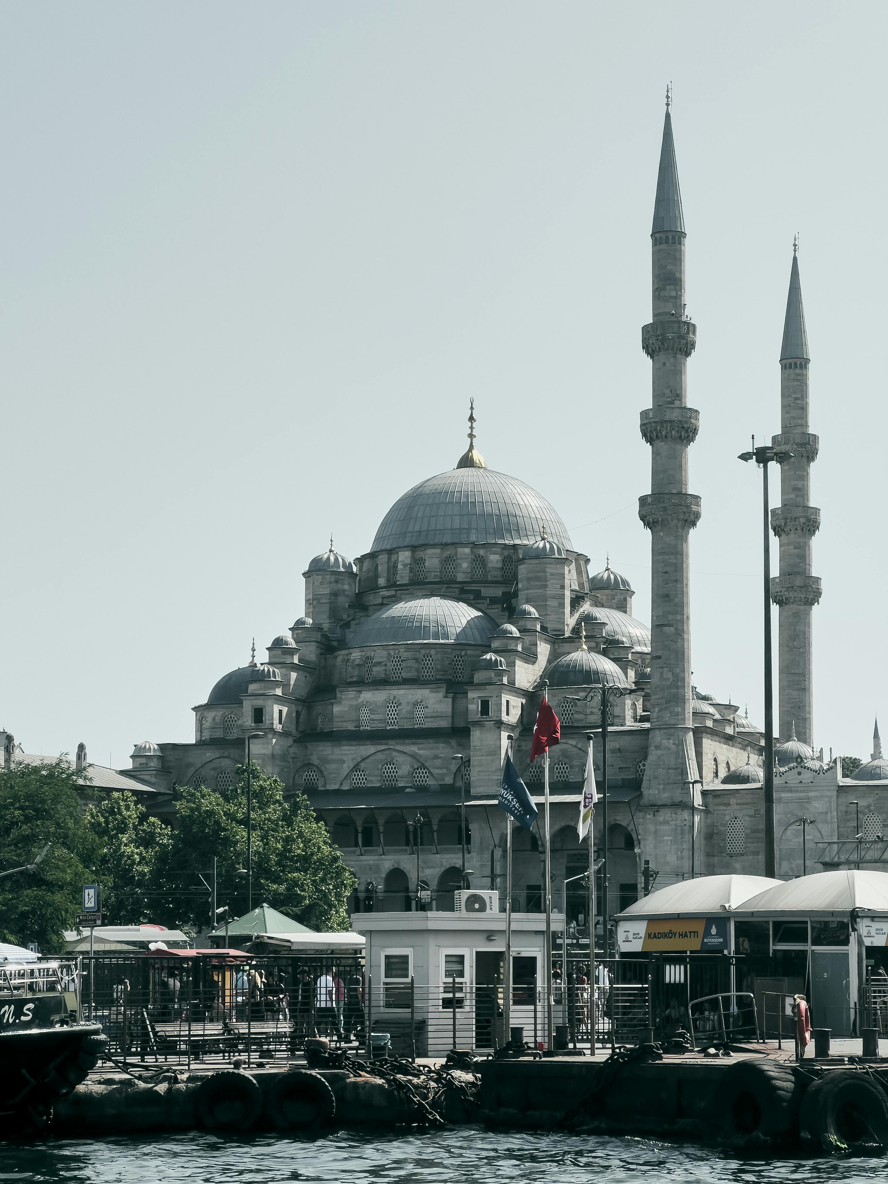 The iconic Yeni Mosque overlooking the Bosphorus in Istanbul, showcasing Ottoman architecture with bustling waterfront.