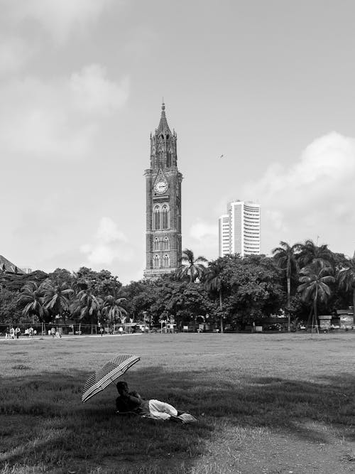 Man Lying in a Park Overlooking the Rajabai Clock Tower