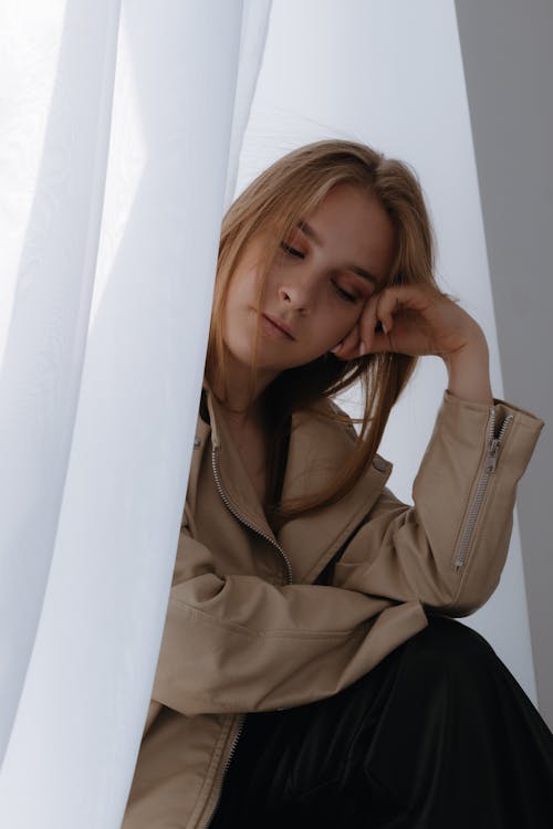 Model Wearing Beige Jacket and Black Leather Pants Sitting on the Window ·  Free Stock Photo