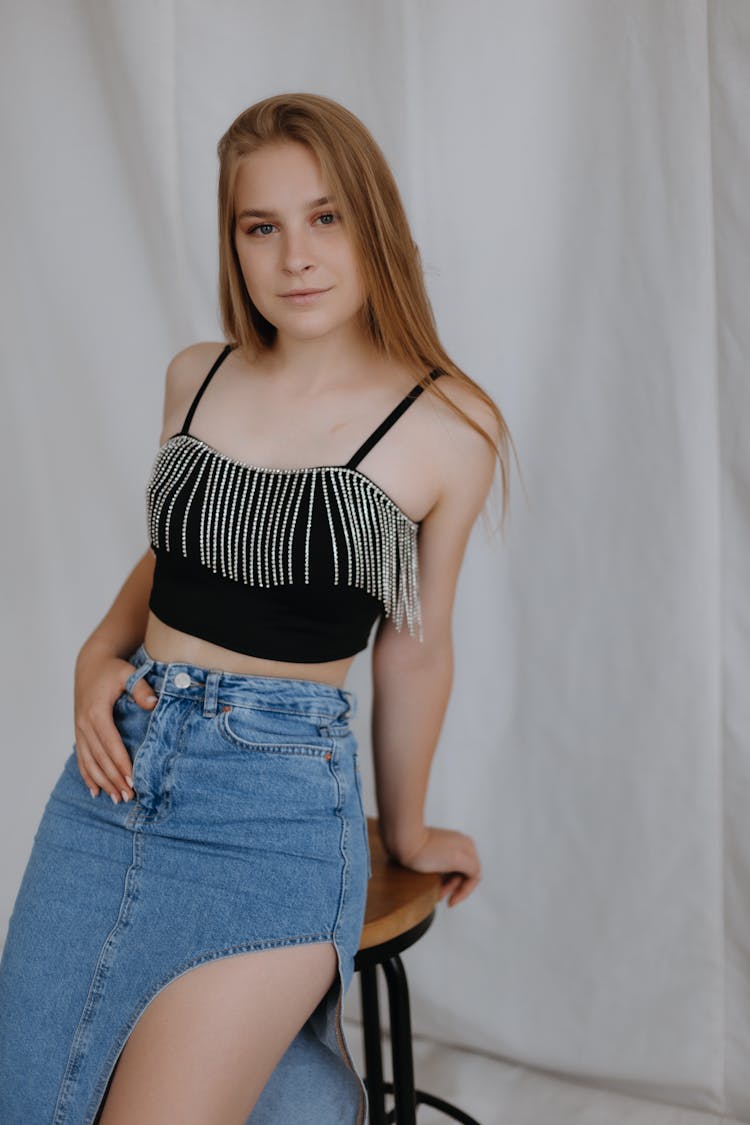 Young Redhead Woman Sitting On Stool In Studio