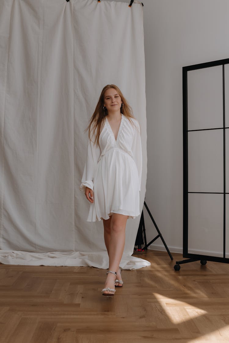 Young Woman In Dress Walking In Studio