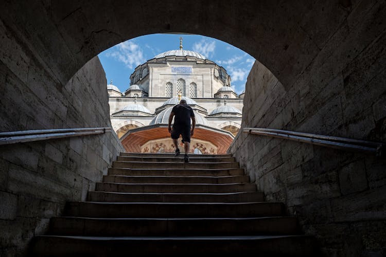 Man Walking On Stairs To Old Mosque