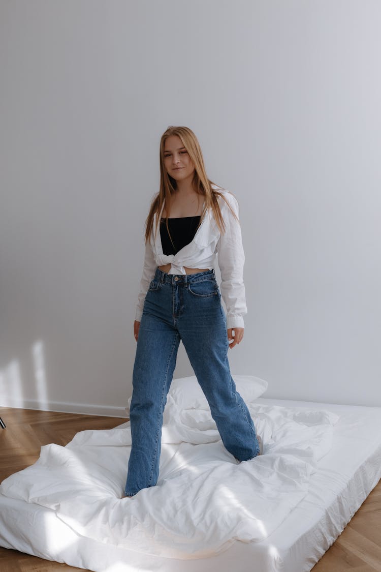 Young Woman Walking On Mattress In Studio