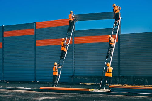 Construction Workers Building a Noise Barrier