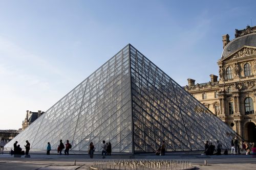 Free The famous glass pyramid at the entrance of the Louvre Museum in Paris with visitors around. Stock Photo