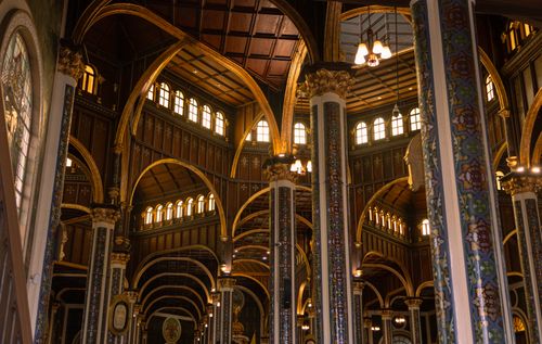 Free Detailed view of the ornate interior of a historic church with golden highlights. Stock Photo