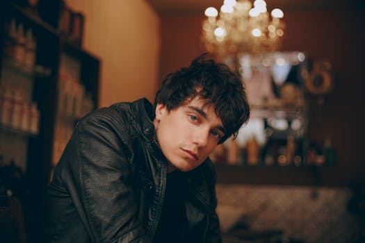 一名穿着皮夹克的年轻人在室内的肖像，背景模糊