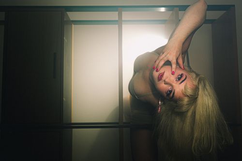 Free Artistic portrait of a blonde woman posing creatively with dramatic lighting effects. Stock Photo