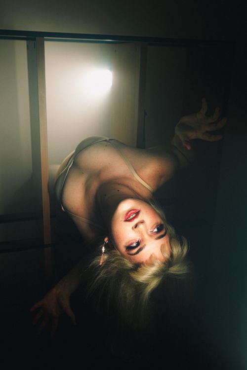 Free A surreal portrait of a woman in dramatic lighting with an artistic pose. Stock Photo