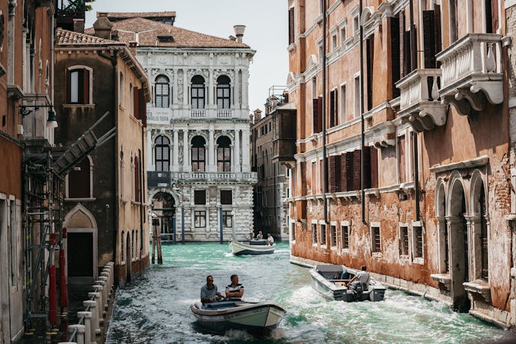 People On Motorboats On Canal In Venice