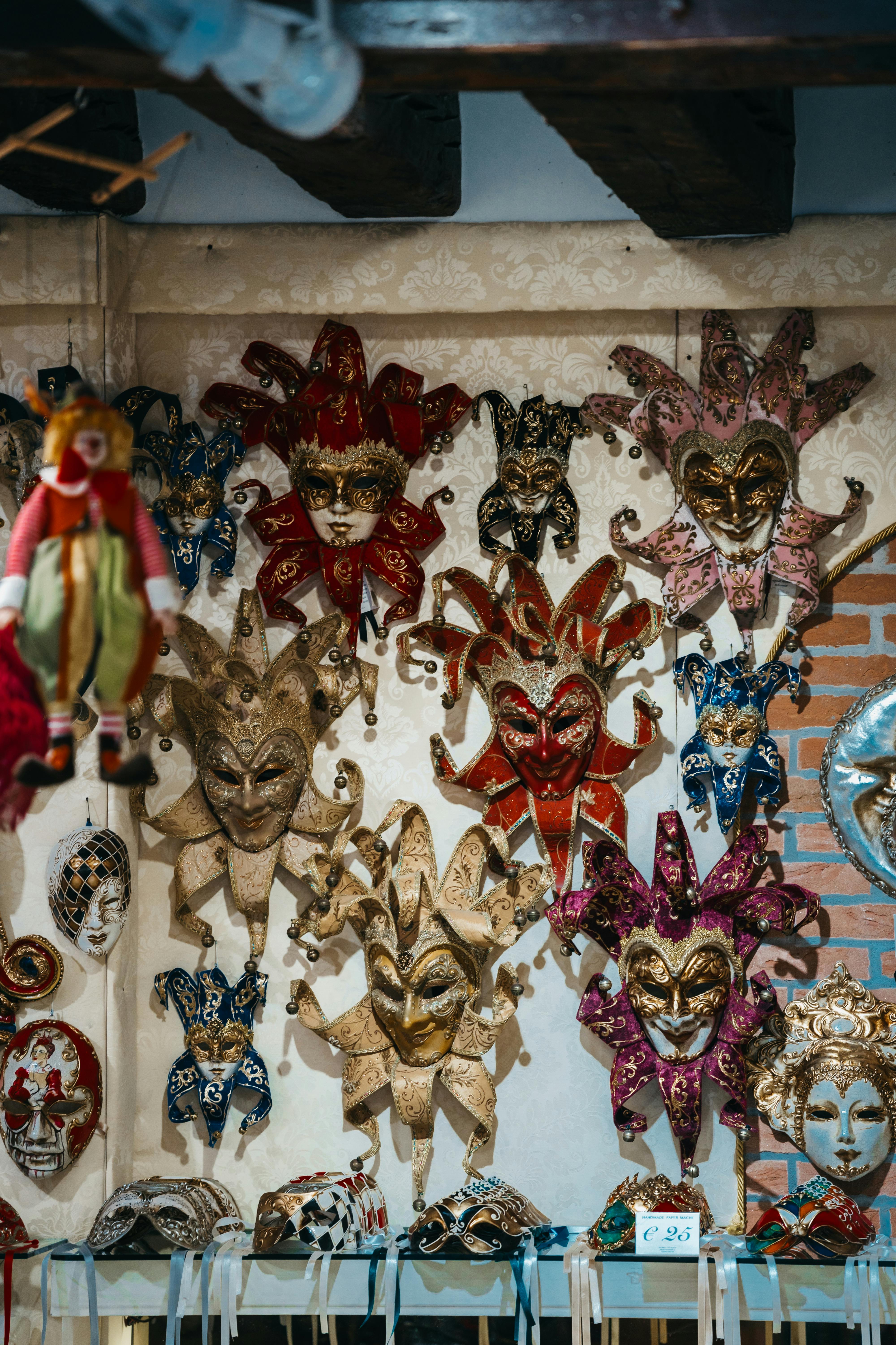 Free A colorful display of decorative Venetian carnival masks on a wall, showcasing ornate craftsmanship. Stock Photo