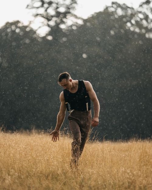 Free A man in a field during rainfall in London, capturing a peaceful rural scene. Stock Photo