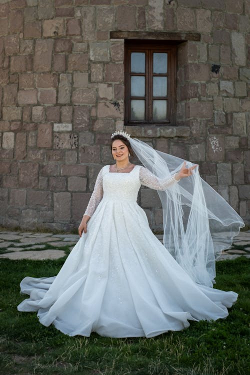 Bride Wearing a Veil Standing in front of a Building 