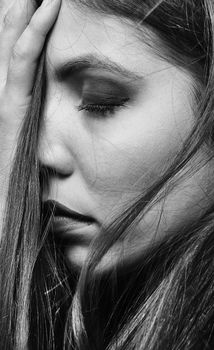 Close-up black and white portrait highlighting feminine beauty and emotional expression.