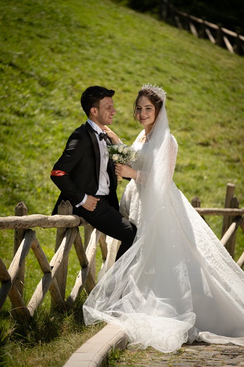 Smiling Newlyweds Posing by Wooden Fence