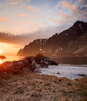 在岩石海岸线上，以山脉为背景，体验日落那迷人之美
