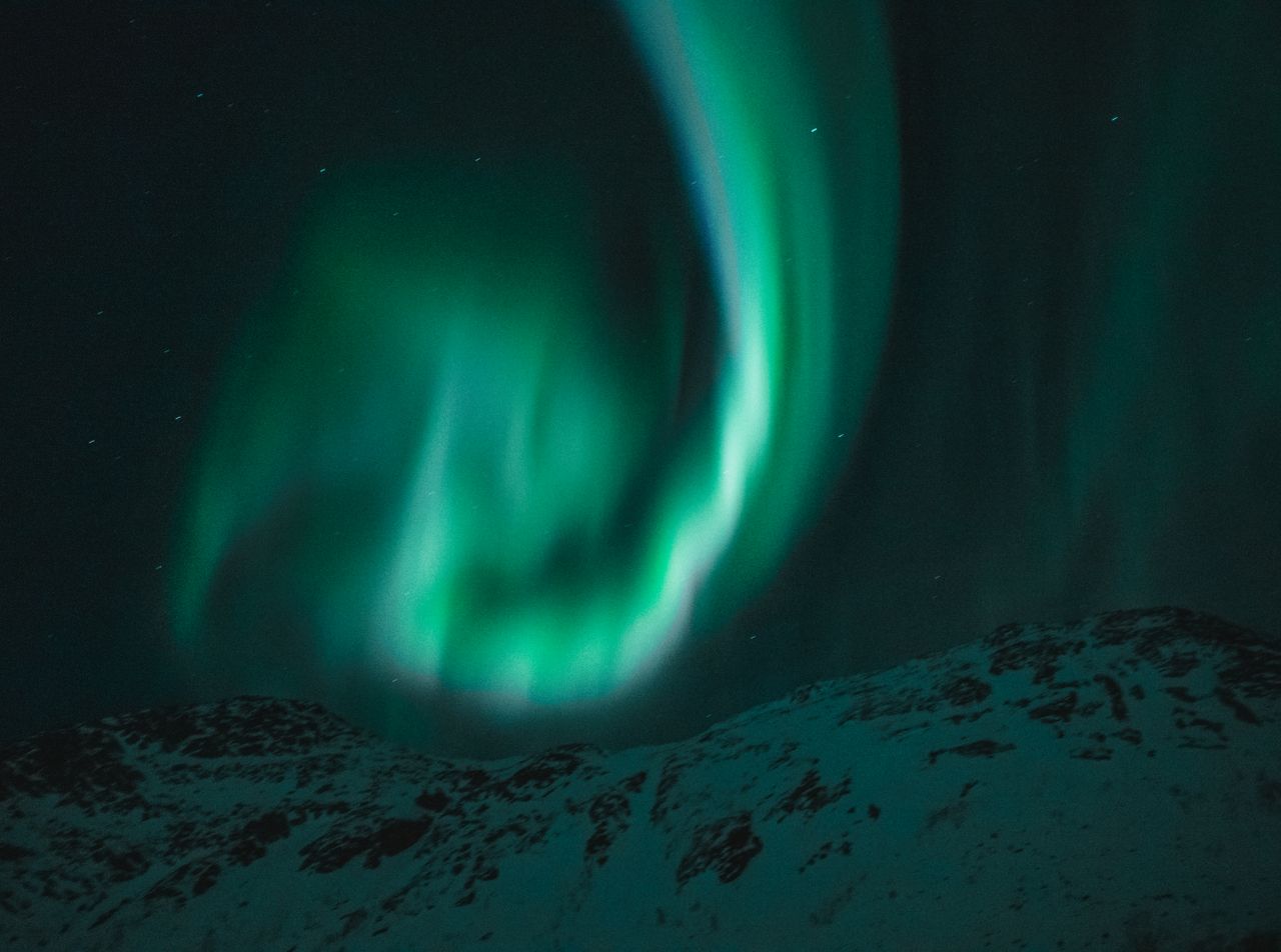 beautiful aurora borealis illuminating the night sky over snow covered