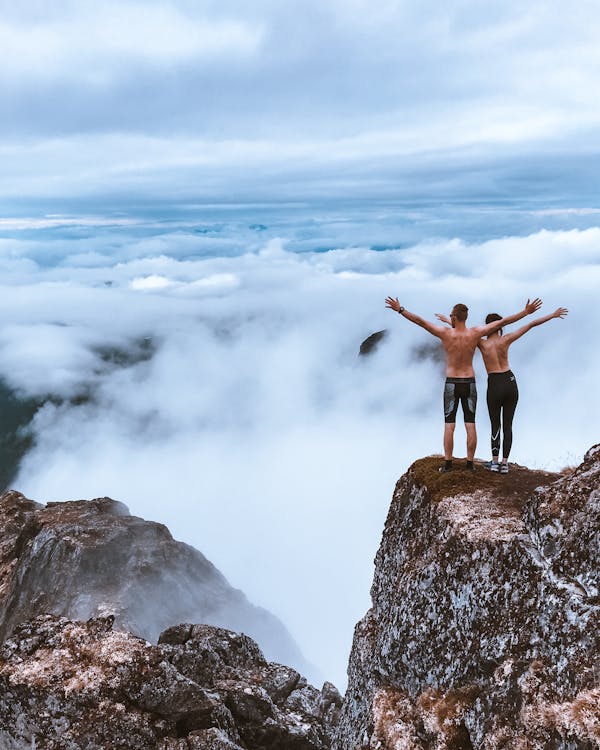 Scenic Photo of People Standing on Cliff