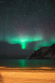 北极光照亮了夜空，白雪覆盖着山脉，湖泊一片宁静