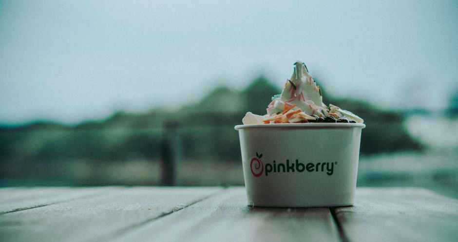 Close-up of a Pinkberry frozen yogurt cup with sprinkles, offering a delicious and indulgent treat.