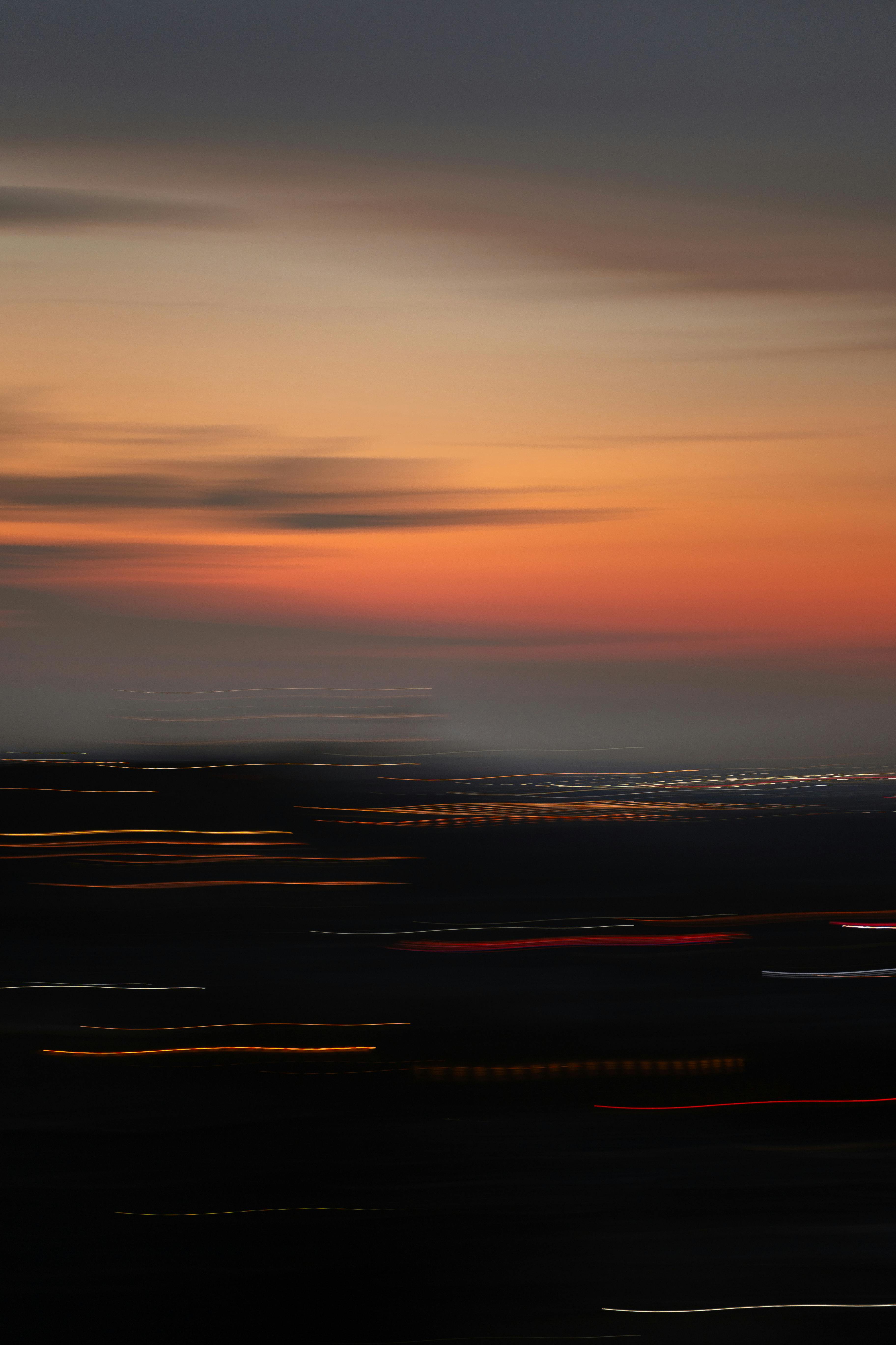 Motion blur of city lights at sunset, creating an abstract colorful scene.