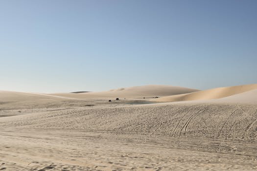 广阔的沙漠中，起伏的沙丘在湛蓝天空下，是隔离与自然美景的缩影
