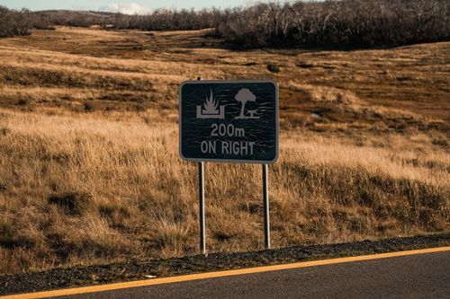 Free Roadside sign indicating a campground 200 meters ahead in a rural area. Stock Photo