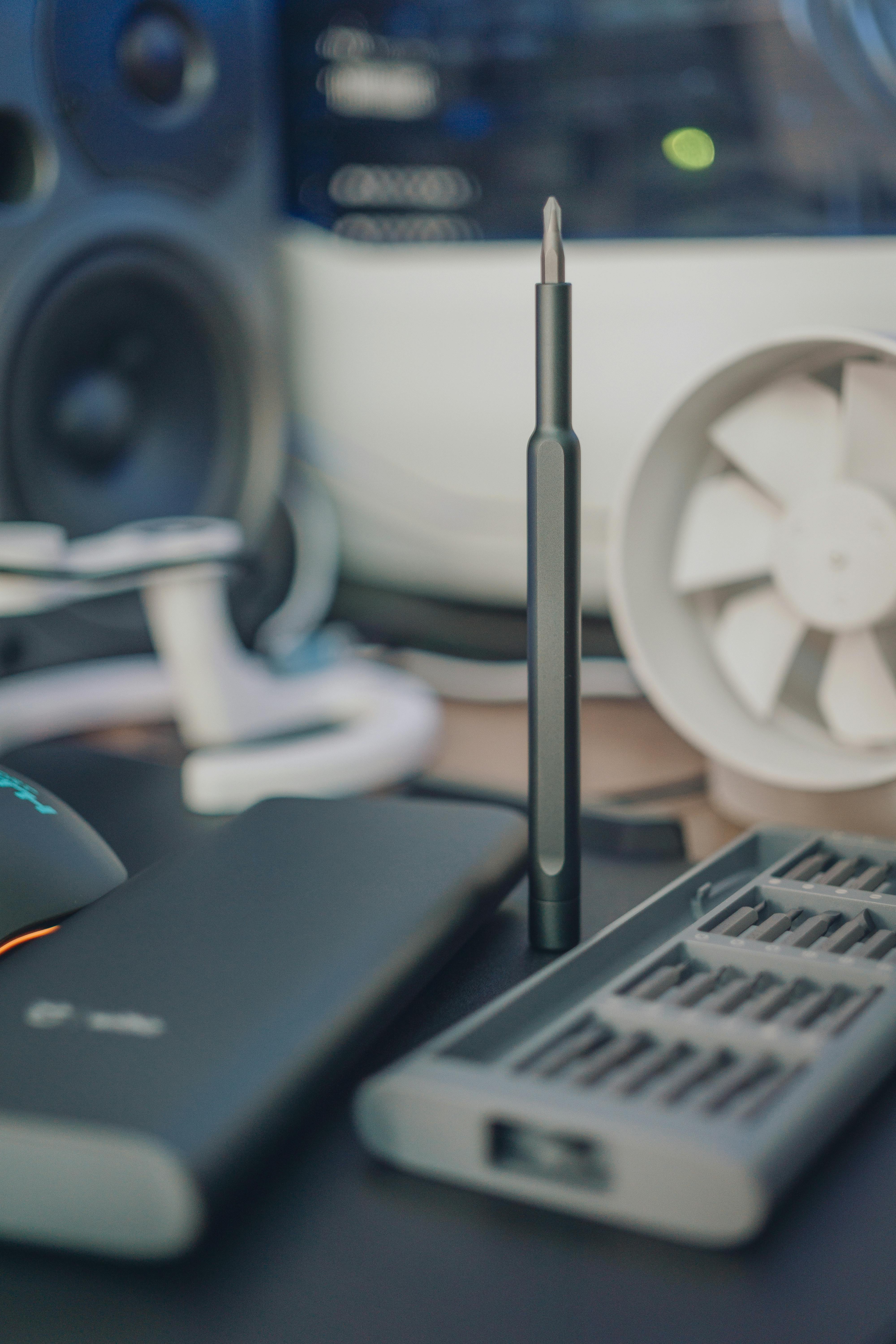 特写镜头下，凌乱的办公桌上放着一把磁性螺丝刀