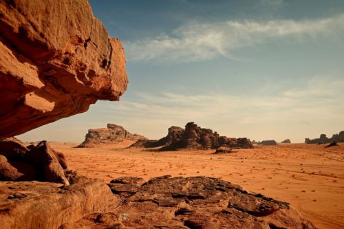 Free Breathtaking view of Wadi Rum's sandstone formations and vast desert landscape under a clear sky. Stock Photo