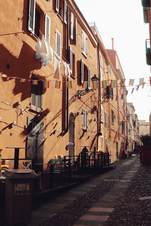 Cobblestone Alley of the Alghero Old Town Decorated with Rainbow Bunting Flags