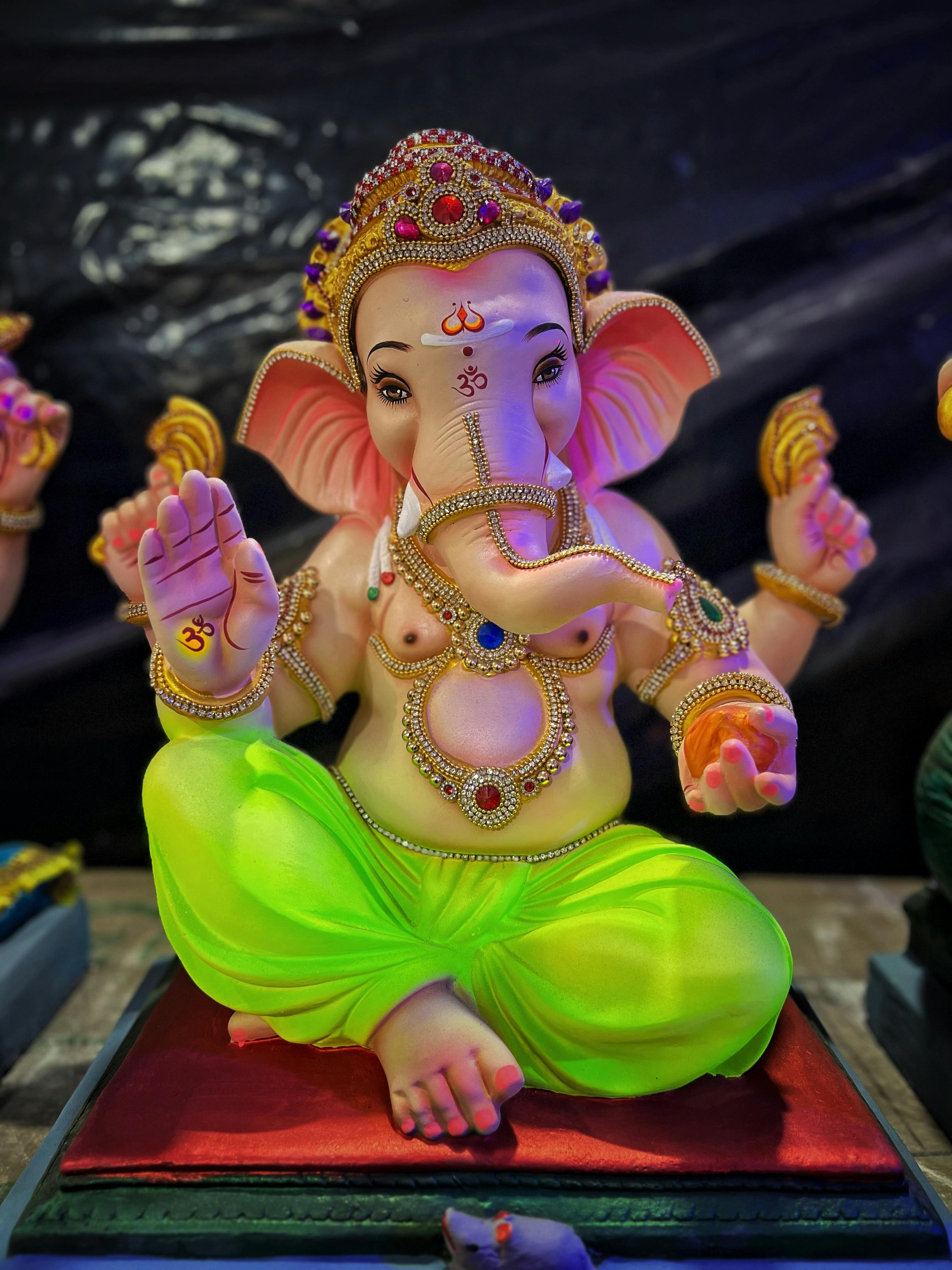 A vibrant statue of Lord Ganesha adorned with jewels and intricate designs, symbolizing Hindu spirituality.
