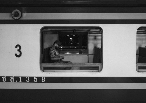 Free Black and white photo of a man sitting alone in a train at night. Stock Photo