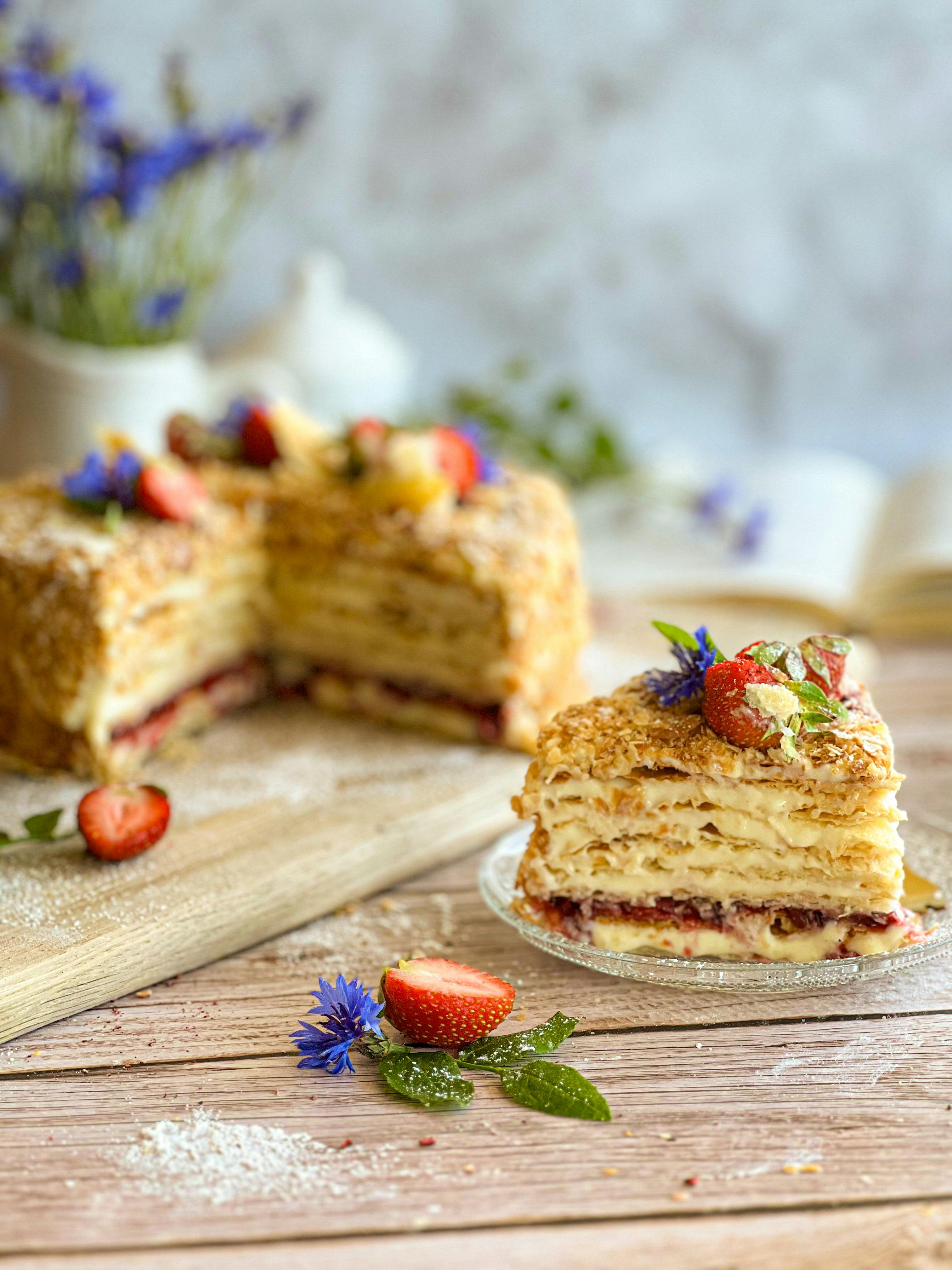 Delicious Napoleon cake adorned with fresh strawberries and cornflowers, perfect for a sweet treat.