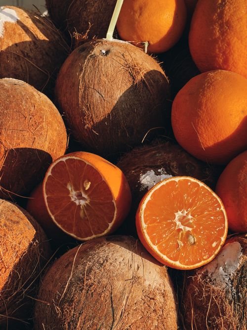 Free A vibrant still life of coconuts and oranges in sunlight, ideal for food photography. Stock Photo