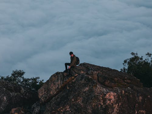 Free Hiker Sitting on a Rock Formation  Stock Photo