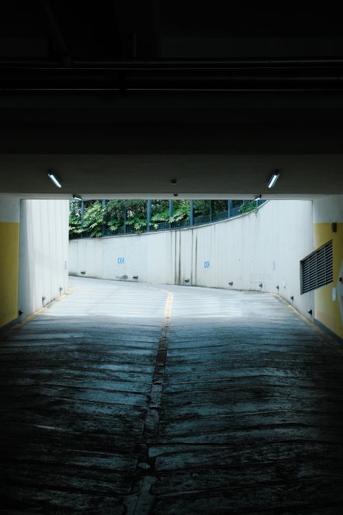 Free A shadowed view of an exit from an underground garage tunnel with curving walls. Stock Photo