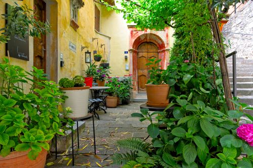 Free Quaint courtyard in Lugano, Switzerland with lush plants and vintage facade. Stock Photo